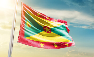 Grenada national flag waving in beautiful sky.
