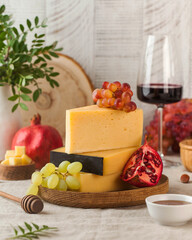 Elegant cheese board featuring a variety of cheeses, grapes, and accompaniments, paired with glasses of red wine