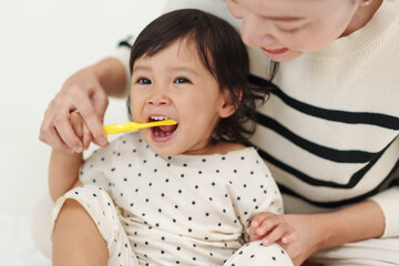 mother brushing her daughters teeth. happy baby with tooth brush
