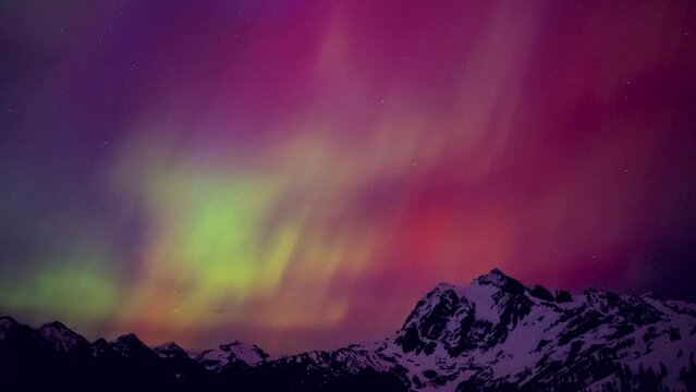 Aurora Borealis Colors Flashing in Night Sky Over Mountain Peak