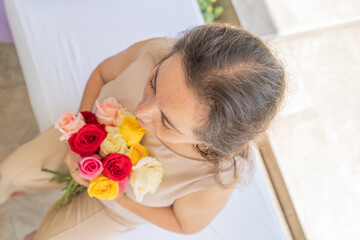 Woman holding a bouquet of roses against her chest