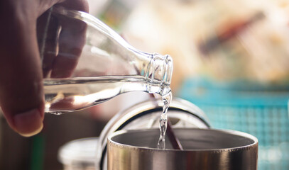 person pouring water into glass