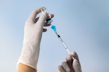 Hand holding syringe with vaccine. Covid-19