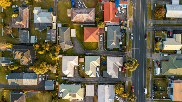 Aerial view of a suburban neighborhood with a construction site in the center, surrounded by residential houses and streets - South Auckland, New Zealand