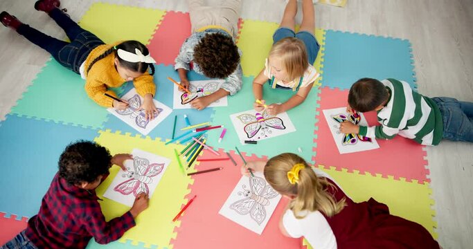 Children, friends and group or drawing in classroom for creative project, back to school or artistic. Boys, girls and pencils on mat floor for learning education for elementary lesson, paper or color