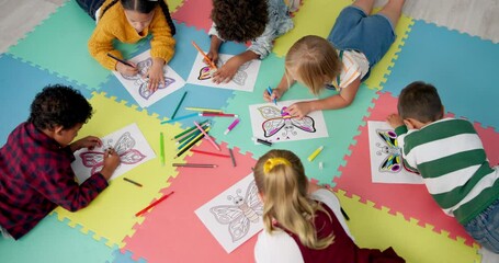 Kindergarten, art and children drawing on classroom floor for color, learning and creative expression lesson. Education, paper or student kids with top view butterfly sketch, picture or group project - Powered by Adobe