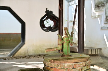 Taiwan - Jan 19, 2024: The traditional Minnan hand water pump, powered by human force, draws groundwater to the surface through manual handle movement for various uses in traditional Minnan architectu