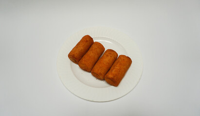Risoles, traditional snack form Indonesia. It filled with carrot, potato, chicken and other vegetables rolled in breadcrumbs then deep fried in a plate on white background.