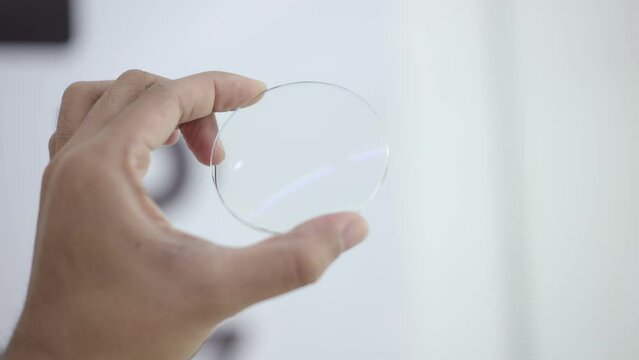 hand pressing glasses lenses in optical store 