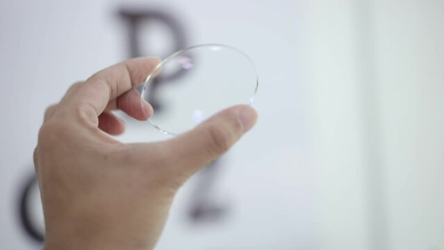 person holding a glasses lenses in optical store 