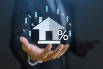 Businessman hold house with percentage, concept of real estate market trends, mortgage rates,...