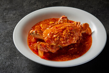 traditional chinese wok fried seafood fresh big meat crab with chilli spicy salted egg yolk cheese cream sauce in plate on dark stone table asian cafe hotel luxury halal food restaurant banquet menu