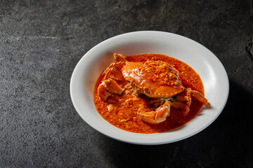 traditional chinese wok fried seafood fresh big meat crab with chilli spicy salted egg yolk cheese cream sauce in plate on dark stone table asian cafe hotel luxury halal food restaurant banquet menu