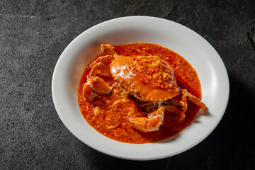traditional chinese wok fried seafood fresh big meat crab with chilli spicy salted egg yolk cheese cream sauce in plate on dark stone table asian cafe hotel luxury halal food restaurant banquet menu