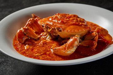traditional chinese wok fried seafood fresh big meat crab with chilli spicy salted egg yolk cheese cream sauce in plate on dark stone table asian cafe hotel luxury halal food restaurant banquet menu