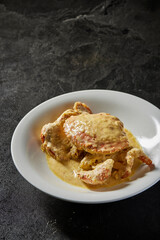 traditional chinese wok fried seafood fresh big meat crab with chilli spicy salted egg yolk cheese cream sauce in plate on dark stone table asian cafe hotel luxury halal food restaurant banquet menu