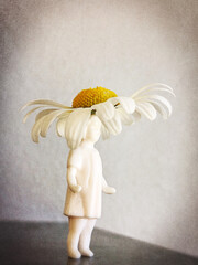 A figurine of a girl with a real flower hat.