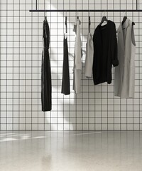 Black and gray dress clothes in modern shop display with white square tile wall, black grout line...