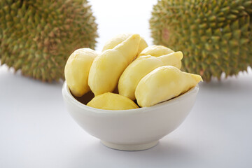 Ripe yellow durian peeled in a white cup, on a white background.