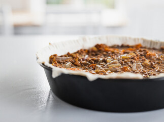 plant-based lentil and pumpkin pie with filling just poured into the pastry before cooking it
