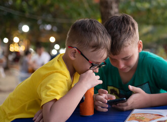 Two boys using mobile phone outdoors 