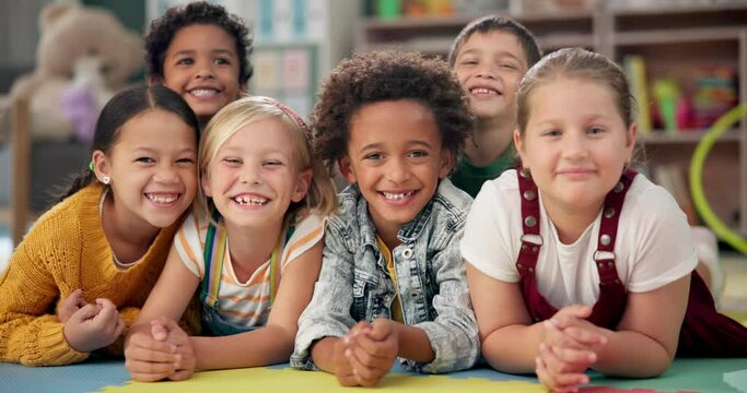 Kindergarten friends, kids and face on floor with smile for education, knowledge and learning at academy. Students, diversity and happy in school for childhood development, scholarship and bonding