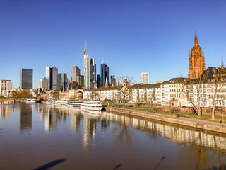 Obraz premium view to Frankfurt skyline with skyscraper and modern cityscape with river Main and cruise ships at pier