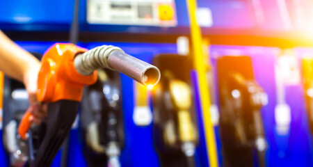 Petrol fuel nozzle in a hand for fuelling in petrol fuel station , horizontal banner with copy space , Fuel and energy concept