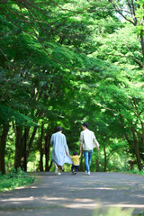 手を繋いで公園を歩く家族	

