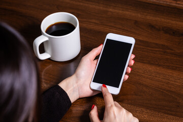スマートフォンを操作する女性の手とコーヒー