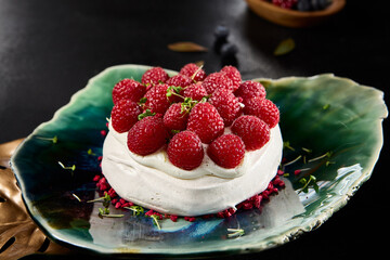 Raspberry Pavlova Dessert Presentation on Elegant Plate, Dark Background