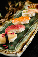 Diverse Sushi Selection with Salmon, Tuna, Shrimp, Eel, Scallop on a Sleek Plate