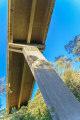 column of a concrete viaduct seen from below with a blue sky in the background