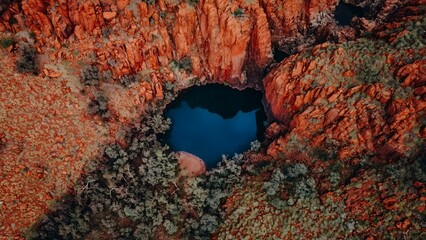 Aerial View of Waterhole Surrounded by Red Rocks in the Pilbara Kimberley Region Western Australia...