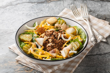 Homemade Cheeseburger Salad with lettuce, ground beef, pickles, cheddar cheese, onions and dressed...