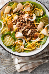 American salad with romaine lettuce, ground beef, pickles, cheddar cheese and croutons with sesame...