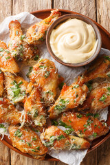 Crispy Parsley Garlic Cheese Chicken Wings Served with Dipping Sauce Close Up in a Plate on the Table. Vertical top view from above