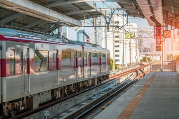 Passenger platform at a train station awaiting the arrival of a commuter electric train.