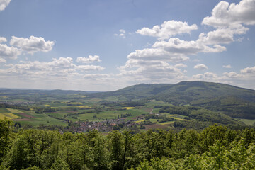Obraz premium Mountain landscape in Germany near Bad-Sooden-Allendorf in the background on a beautiful sunny day with blue sky and clouds in springtime. High quality photo