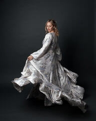 portrait of beautiful blonde female model wearing romantic historical gown white bridal floral...