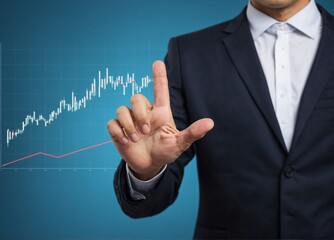 A businessman is shown standing and touching a graph in finance on a blue background.