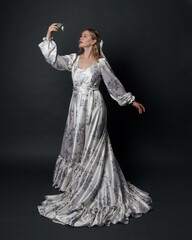 portrait of beautiful blonde female model wearing romantic historical gown white bridal floral...