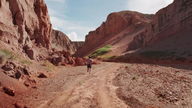Young sporty runner athlete is training and running at big red canyon. Gobi desert, Mongolia