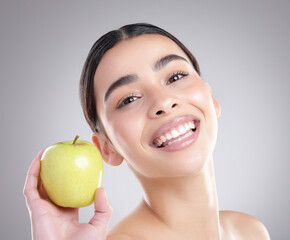 Apple, skincare and portrait with natural woman in studio on gray background for diet, health or...