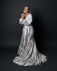 portrait of beautiful blonde female model wearing romantic historical gown white bridal floral...