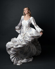 portrait of beautiful blonde female model wearing romantic historical gown white bridal floral...