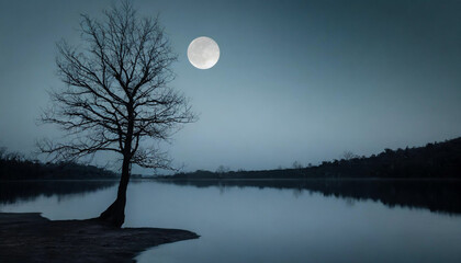 Solitary tree stands at night under the moon