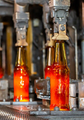 Glass factory, production of glass containers. Molten glass is blown into molds. Robotics in industry. Modern technologies, robotic machines produce products. Technological work at the plant.