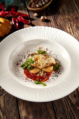 Baked eggplant roll with cheese and tomatoes, elegantly plated on a white dish