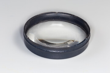 Simple plano-convex metal frame lens on a gray background